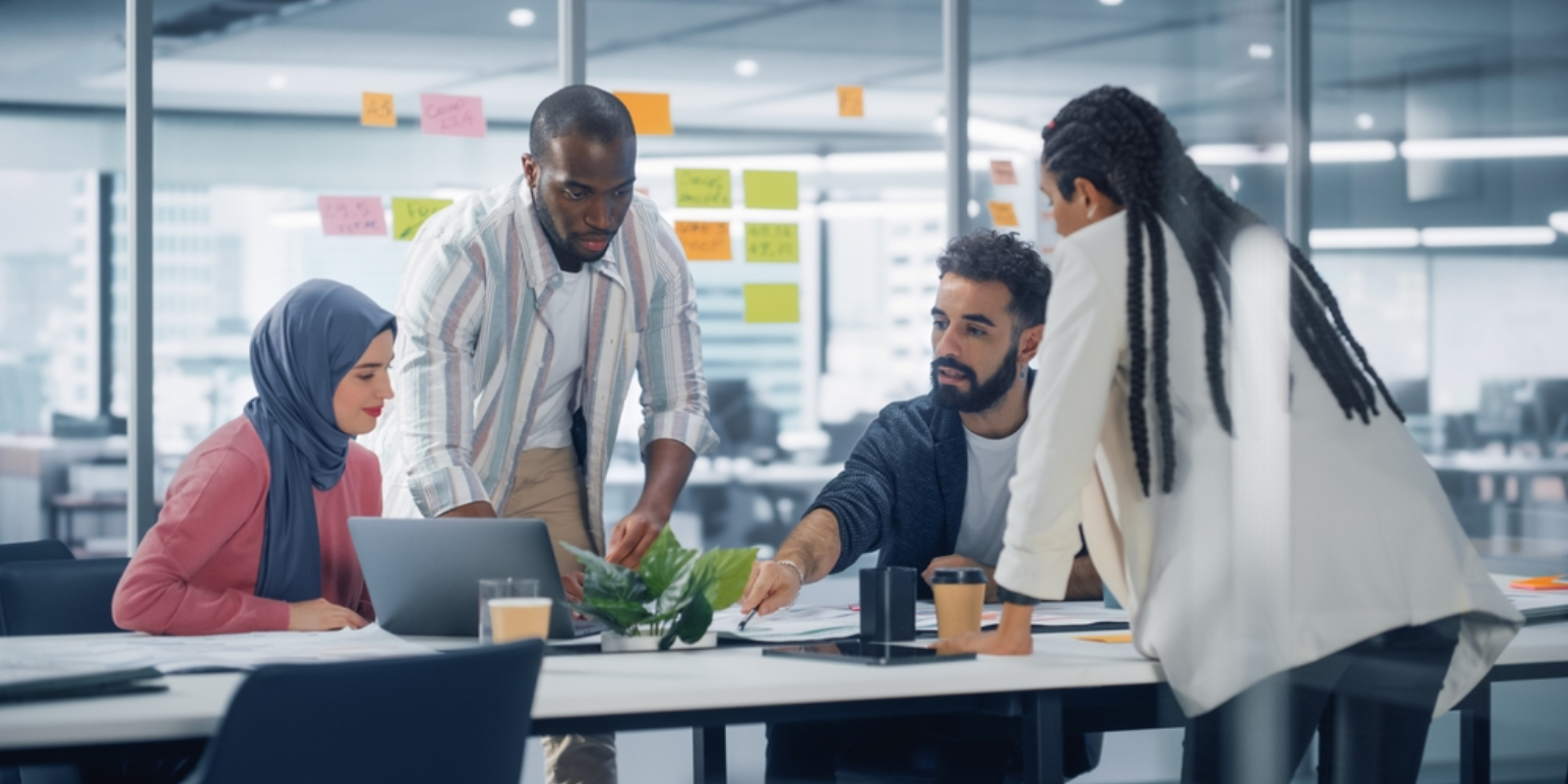 Project professionals meeting around a desk in a modern office