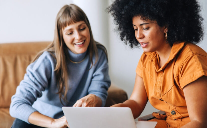 two women mangers looking at a laptop screen