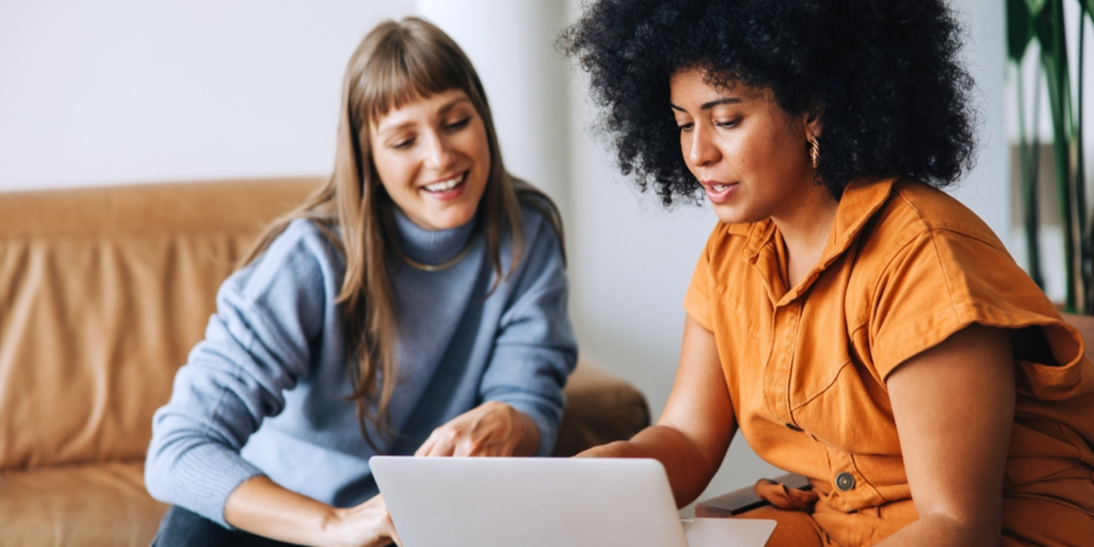 two women mangers looking at a laptop screen