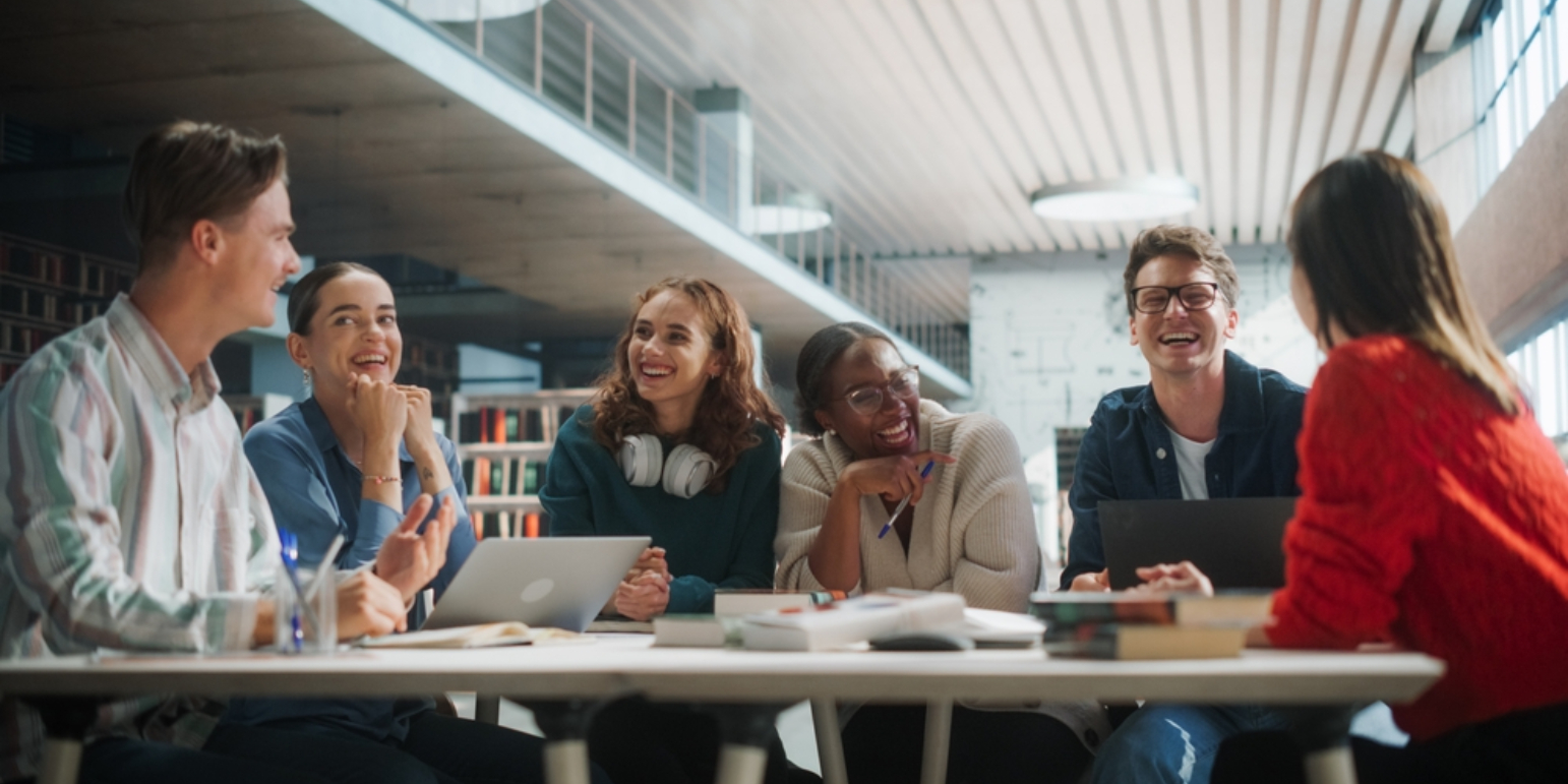 Group if office workers at a desk smiling